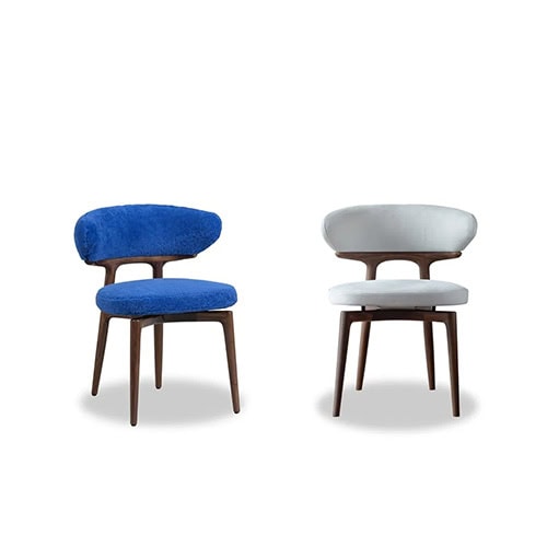 The Bax Clotilde Chair showcases a sculptural wooden frame with a soft, inviting seat. Bold in cobalt blue and serene in light grey, it is perfect for elevating contemporary spaces with refined comfort.