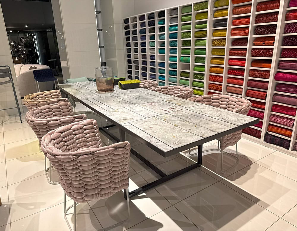 PL Sciara Outdoor Dining Table Gray displays a sculptural top of stone-like tiles in muted tones. Its clean lines and dark metal base deliver a contemporary edge while honoring organic texture and outdoor durability.